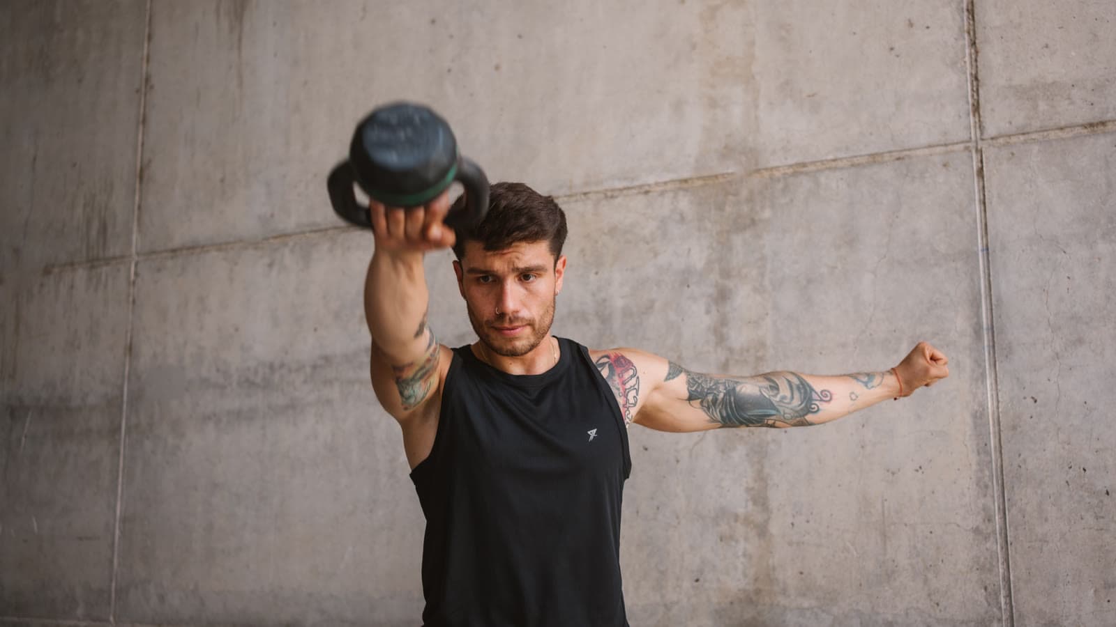 Erick entrenando con una kettlebell frente a una pared de hormigón